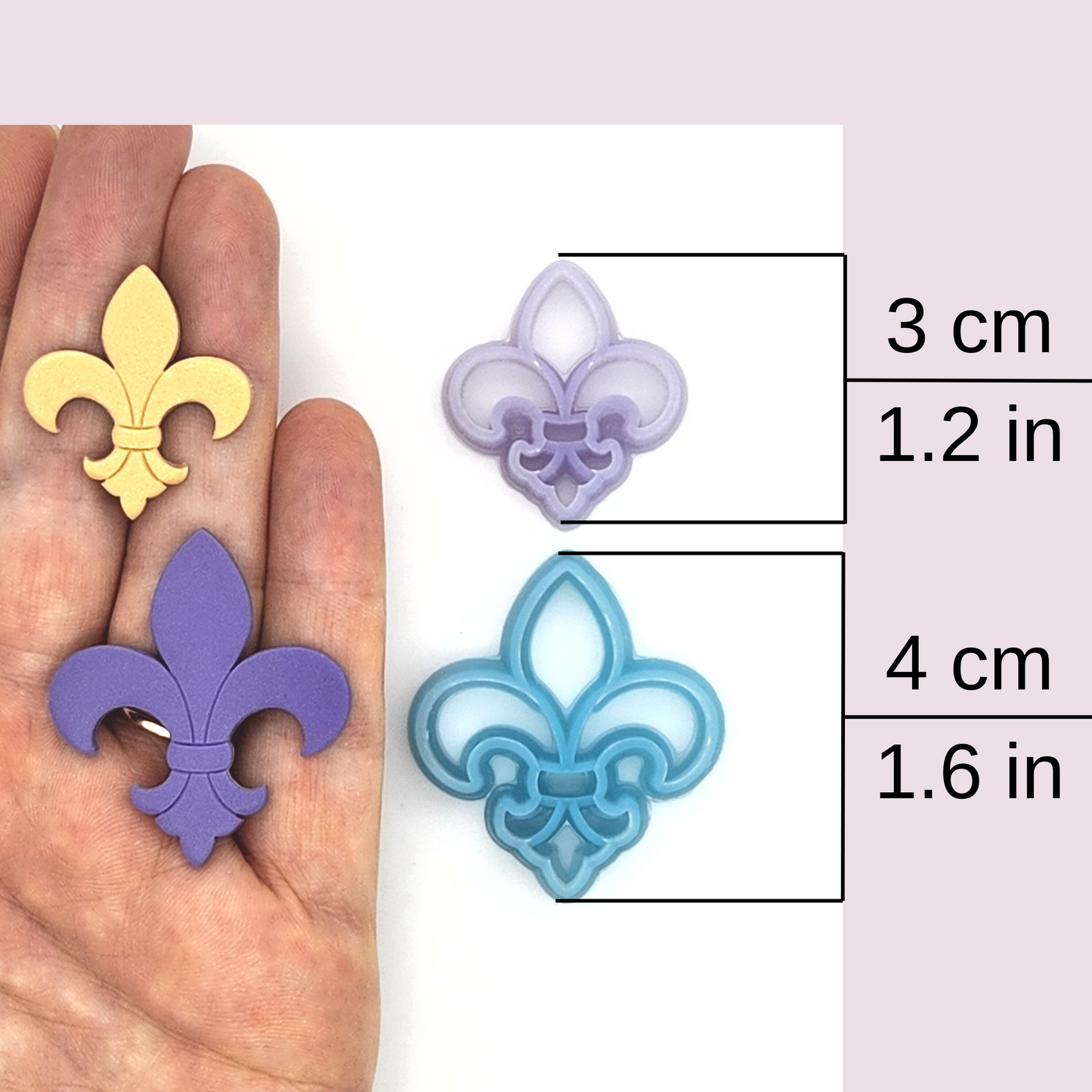 A collection of fleur-de-lis-shaped polymer clay cutters and clay pieces indicating the sizes as 3 cm (1.2 in) and 4 cm (1.6 in)