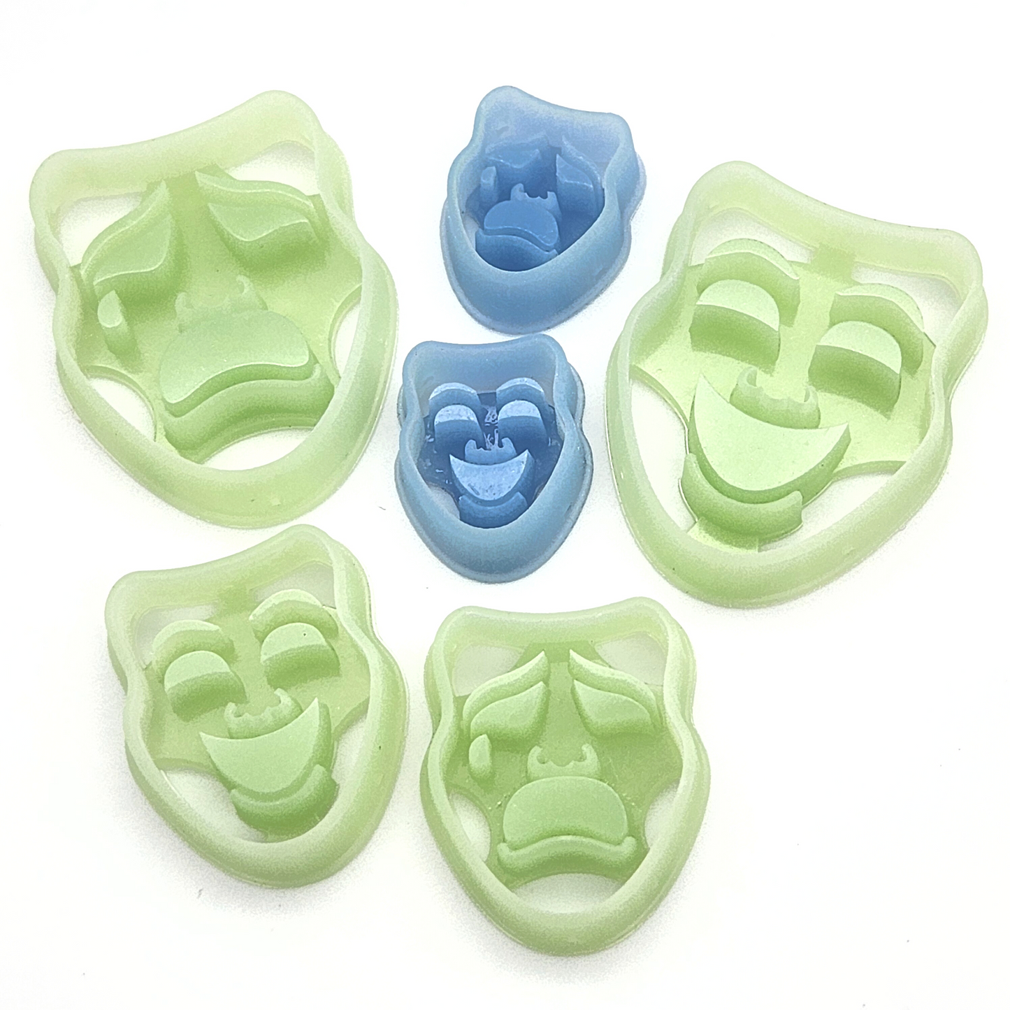 multiple polymer clay cutters, shaped like classic theater masks with expressive faces