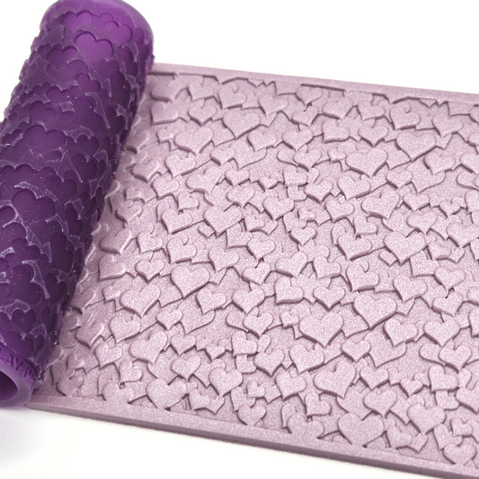 Scattered hearts pattern texture roller with sample on polymer clay slab