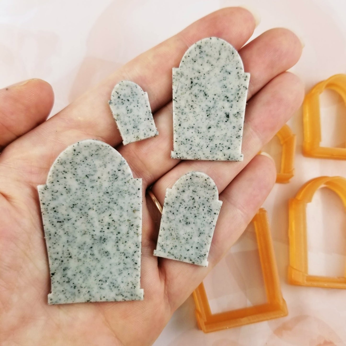 Headstone polymer clay cutters seen on hand for scale.