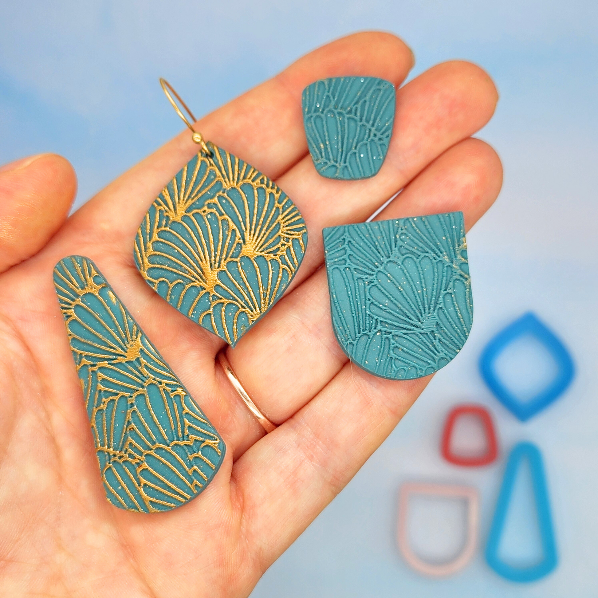 Abstract shell pattern embossed on various polymer clay shapes.