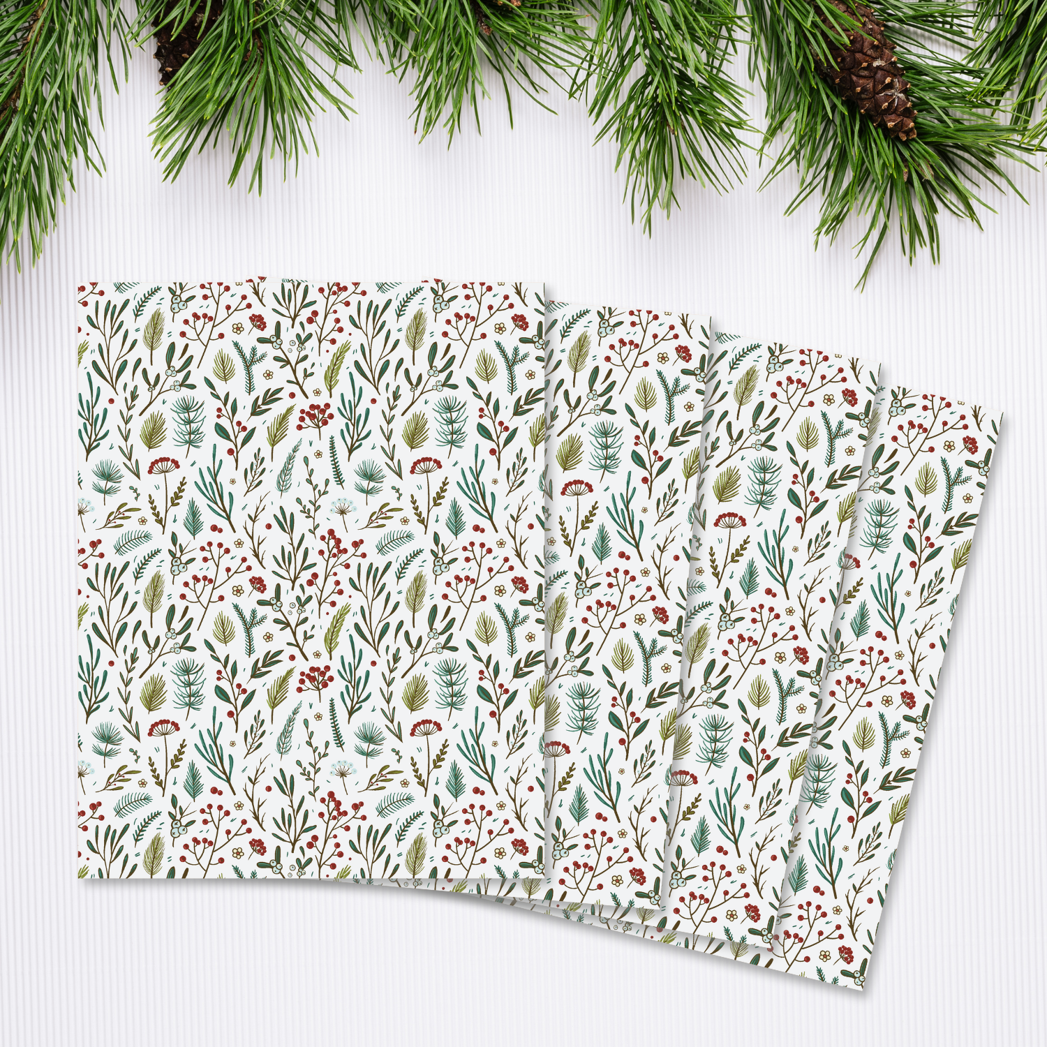 Christmas transfer sheets adorned with floral patterns and pine needles.