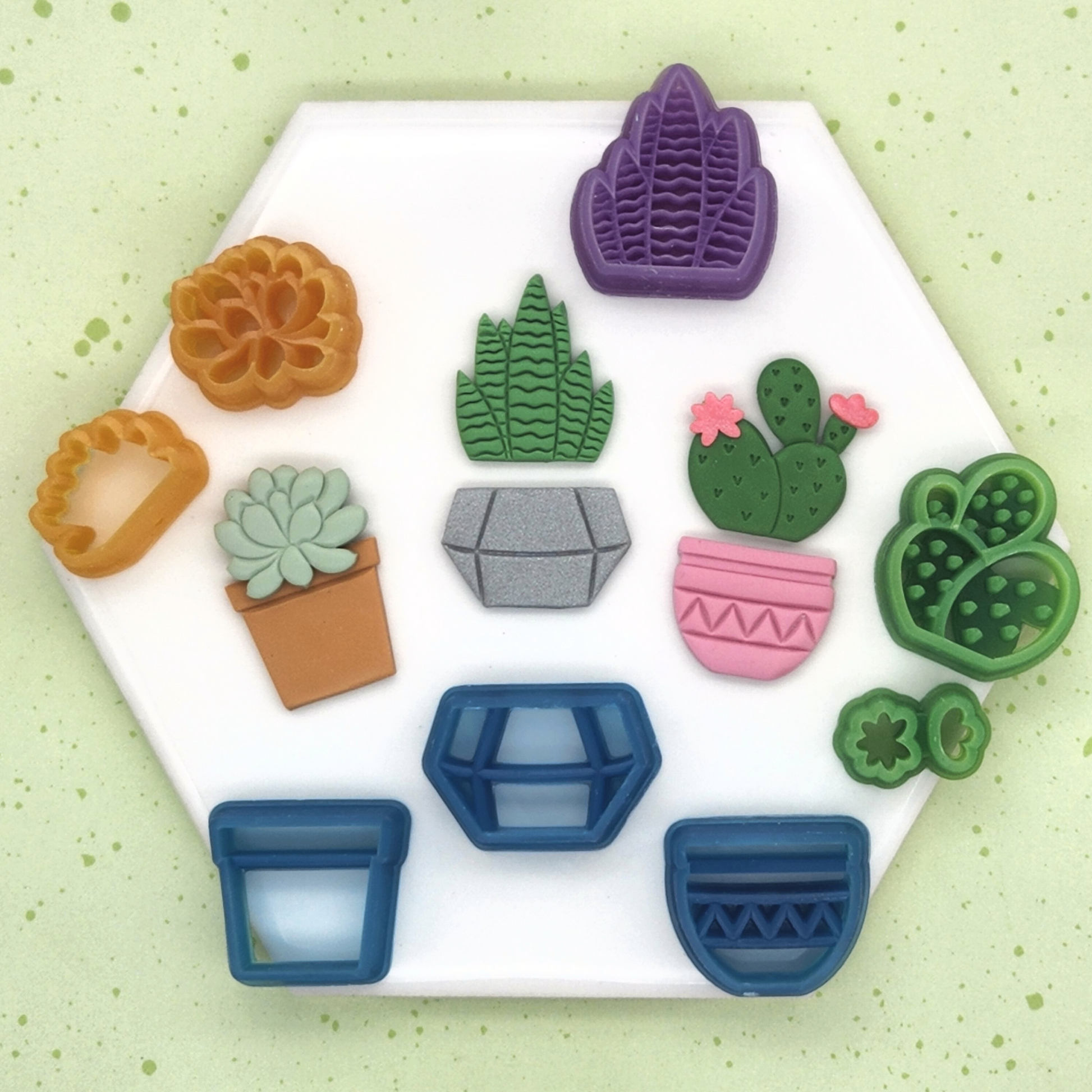 Full set of Potted plants cutters and polymer clay samples. Included in the set are Cactus and Flowers Cutter Set, Snake Plant Cutter, Succulent and Back piece Cutter Set, Geometric Pot Cutter, Teracotta Pot Cutter, and Zigzag Pot Cutter.