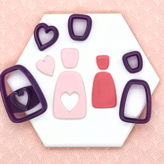 Amara Set has two sets, outline set: two piece shape cutters including stud and dangle, and cutout set: three piece set cutters including stud, dangle and heart shaped cutter. In photo, Amara set, outline and cutout set cutters with sample polymer clay fi