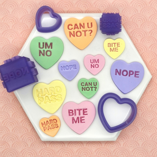 candy conversation hearts clay cutters with debossing cube with words "CAN U NOT?", "BITE ME", "UM NO", "NOPE", and "HARD PASS". In photo sample finish product on polymer clay and Sour Tarts Debossing Cube and Cutter