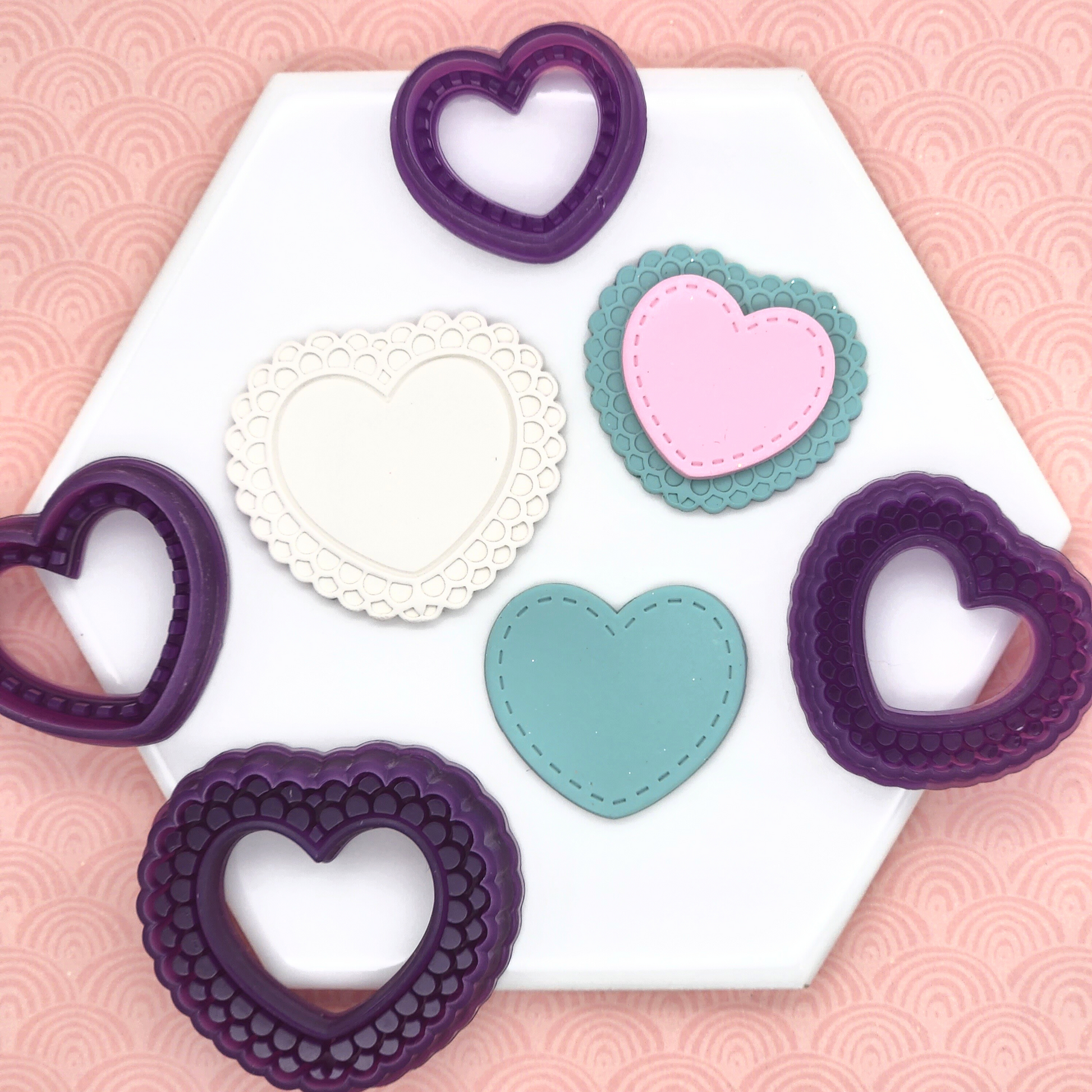Stitched and Doily Heart Set is composed of a heart shaped doily like outline pattern cutter, and a smaller heart shaped stitch outline pattern cutter. In photo, Stitched and Doily Heart Cutter Set with sample polymer clay finish product