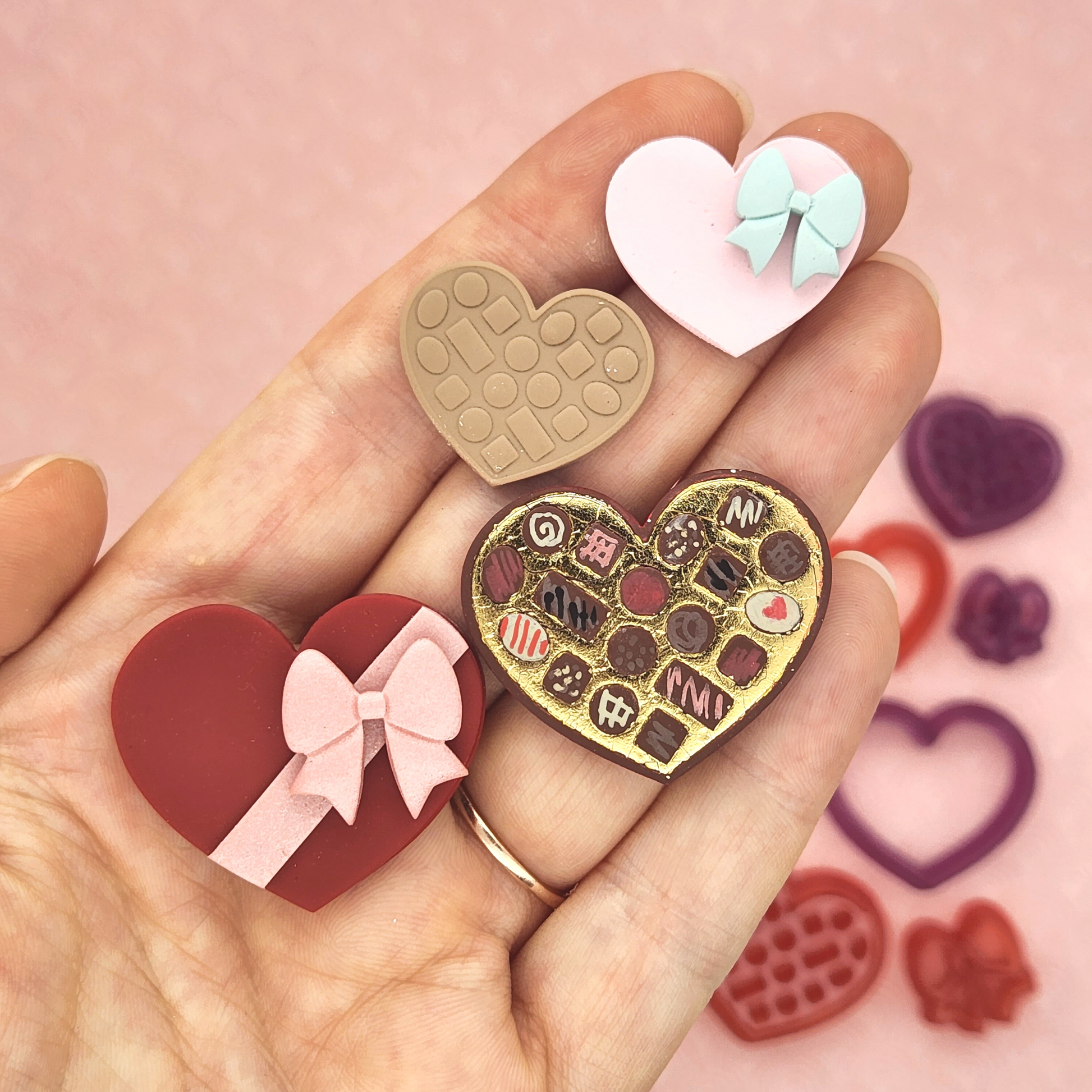 Polymer clay box of chocolates. Heart shaped box with debossed shaped to look like mini chocolates inside the box, and heart shaped lid with bow on top