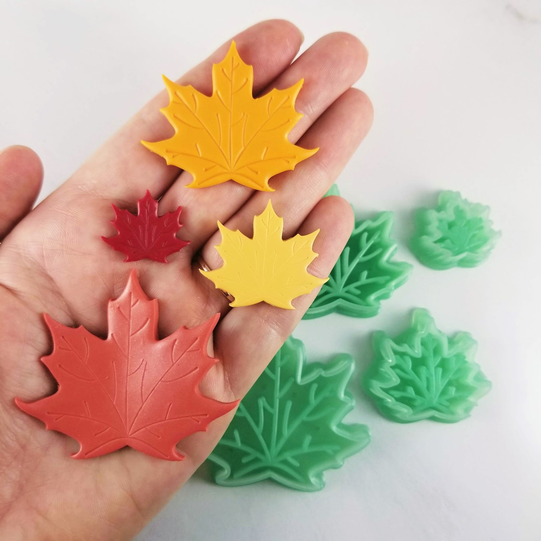 Maple Leaf Polymer Clay Cutters in different sizes on hand for scale. 
