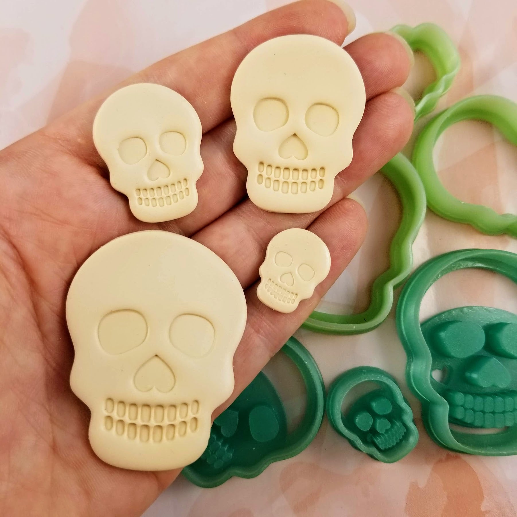 Debossing/embossing skull polymer clay cutters on hand for scale. 