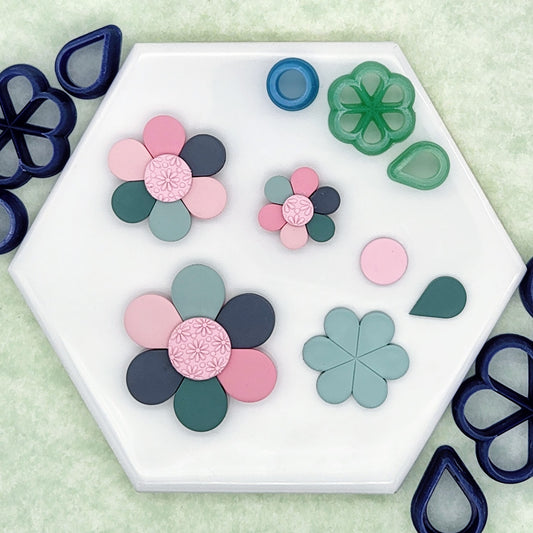 daisy flower polymer clay cutter set. Includes cutter for backpiece, each teardrop shape petal, and debossed circular center cutter.